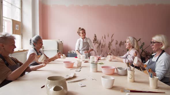 Female Novice Ceramists Working in Art Studio alt