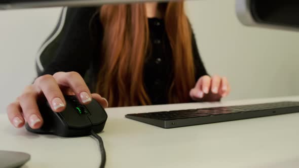 Close Up Vieq of Woman Hand Scrolling Mouse and Typing Text on Keyboard on the Computer Desk alt