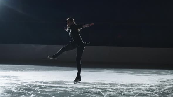 Skaters Warmup on the Indoor Ice Arena in the Dark with Spotlights alt