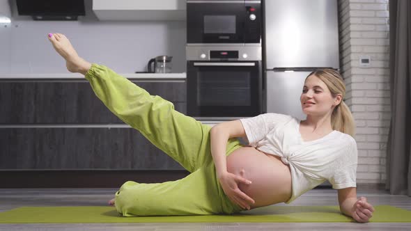 Attractive Pregnant Lady a Woman in Sports Clothes Does Yoga and Fitness for Pregnant Women Sitting