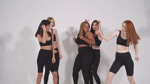 Optimistic Model Girls Dance on a White Background in Studio