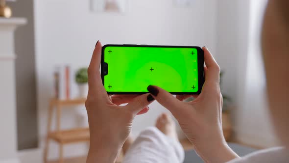 Young Female Using Smart Phone Sitting On Sofa At Home.