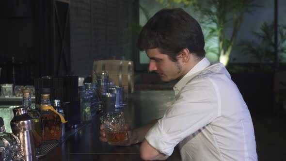 Young Handsome Man Drinking Whiskey at the Bar Alone Smiling Cheerfully To the Camera