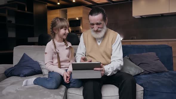 Girl Sitting on the Couch with Her Respected Bearded Senior Grandfather alt