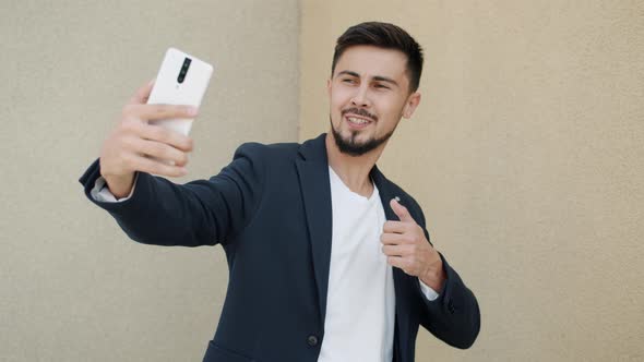 Handsome Mixed Race Man Posing for Smart Phone Camera Taking Selfie Outdoors alt