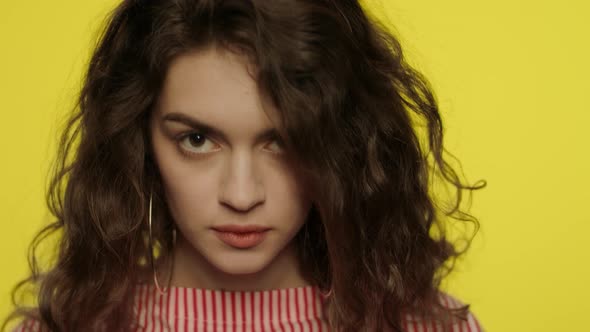 Shocked Woman Open Mouth. Shock Girl Closing Mouth with Hands in Yellow Studio alt