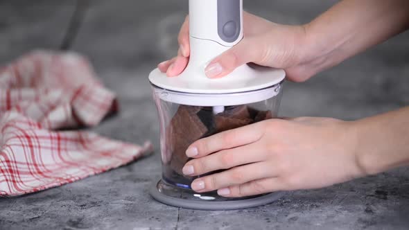 Female Hands Grinding Chocolate Cookies in a Blender alt