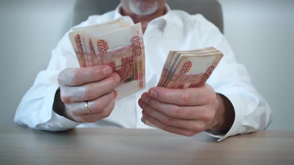 Closeup of an Unrecognizable Businessman Counting Cash of Five Thousand Russian Ruble Banknotes