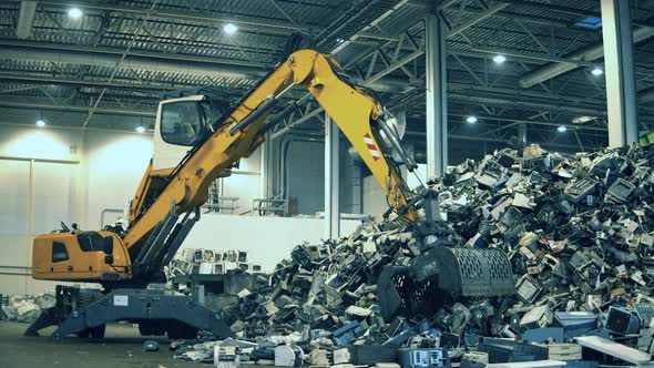 Excavator Is Grabbing Pieces of Garbage From a Pile. Recycling Industry, Used Electronic Recycling alt