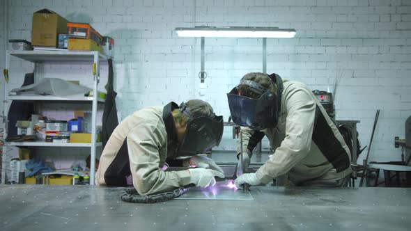 Two Welders are Working in the Workshop