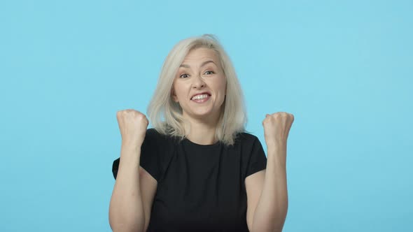 Slowmotion Happy Cheerful Triumphing Blond Woman in Black Tshirt Hear Great News Positive Results alt