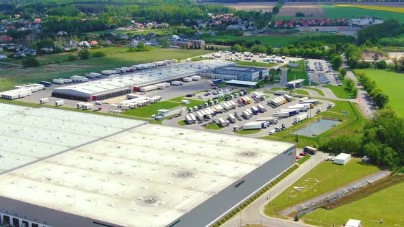 Trucks with semi-trailers stand on the parking lot of the logistics park with loading hub and wait f alt