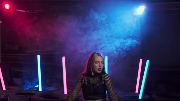 Sexy Woman Enjoying Modern Dance in Smoky Studio with Neon Light alt