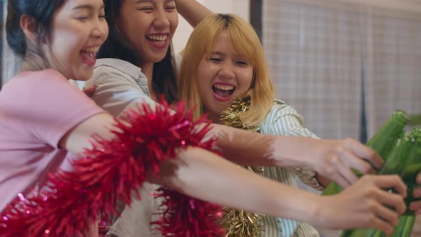 Female drinking beer dancing and singing having funny together in living room in night. alt