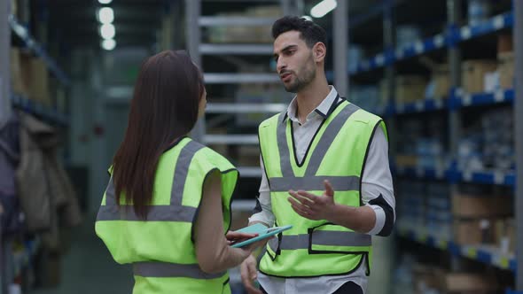 Middle Eastern Warehouse Worker Calming Down Supporting Upset Caucasian Colleague at Workplace alt
