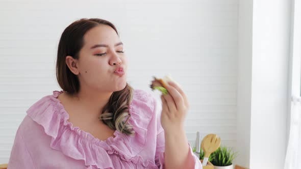 Plus size woman eating vegetable salad and sandwich. healthy food choice, diet