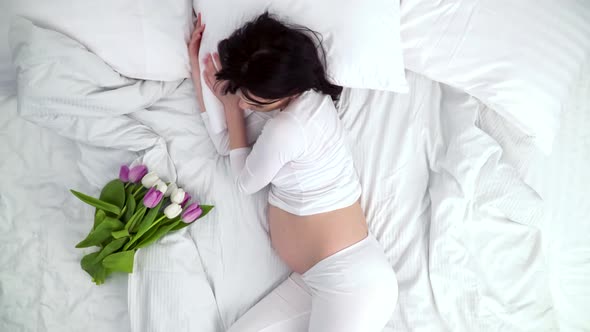Flowers For Pregnant Woman. Beautiful Female Sleeping In Bed alt