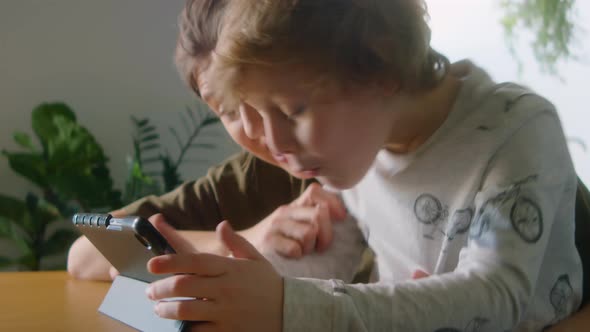 Excited Boy Playing on Digital Tablet with Mother at Home alt