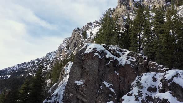 Rising up along cliffs in winter viewing snow covered mountain alt