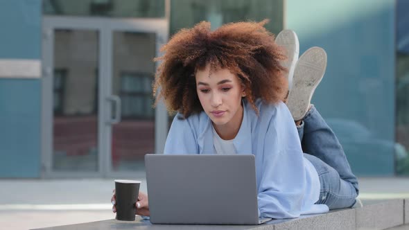 African Girl Student Afro American Business Woman with Curly Hair Freelancer User Lying Outdoors alt