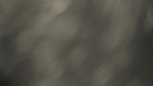 Floating Different Sized Flecks of Dust Flying on Black Background. alt