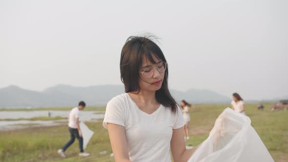 young Asia lady volunteers help to keep nature clean up, looking at camera.