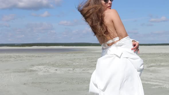 Charming Woman Standing on Beach on Windy Day