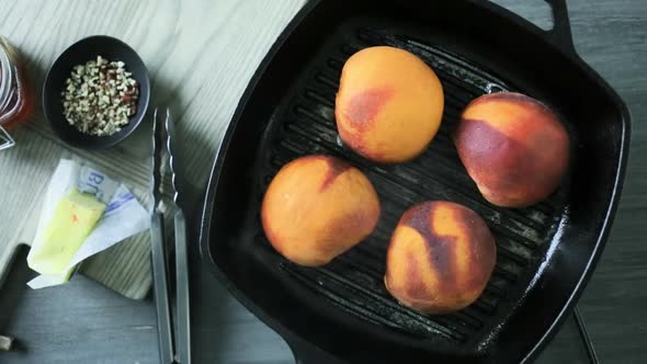 Grilling organic peaches in cast iron skillet. alt