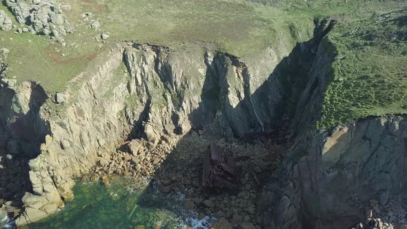 Flyover Ruins Of RMS Mulheim A Shipwreck In Cornwall United Kingdom - aerial shot alt