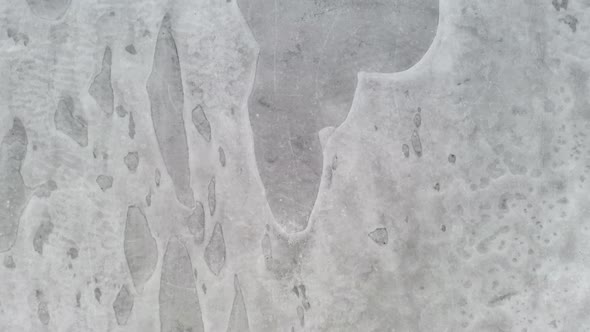 AERIAL: Vertical Drone Shot of Flying Very Low and Close to the Frozen Lake Surface 