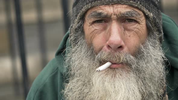 old homeless smoking: closeup portrait of a real homeless alt