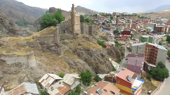 Old Fortress Walls and Watchtower of Castle Behind the Houses in the Small Town alt