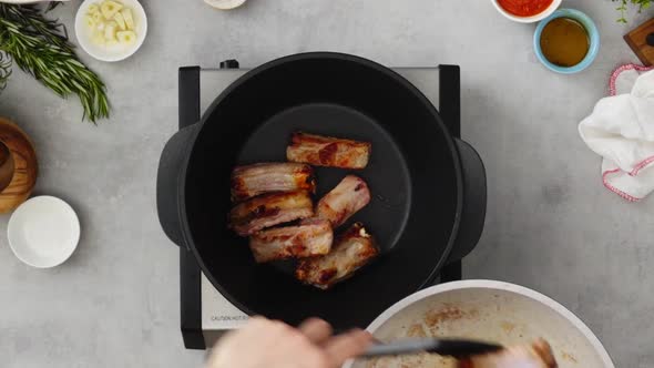 Crop person cooking ribs on pan alt