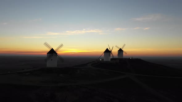 Aerial view of windmills in the countryside in Spain at sunrise alt