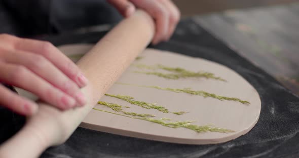 The Master Leaves the Imprint of the Plants on the Clay Board in Pottery Studio alt
