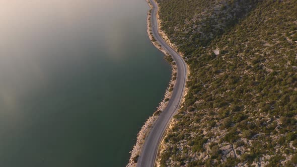 Aerial Drone View on Narrow Road with Cars Between Sea and Mountains alt