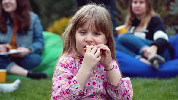  Little Girl Eating a Hot Dog in the Backyard