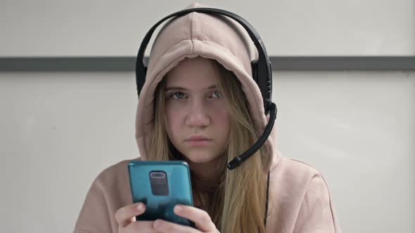 Teen Girl Holding Phone Obsessed with Smartphone Social Media Apps Sitting Alone at Home alt