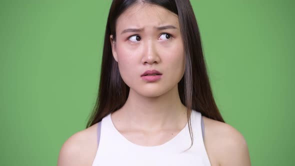 Young Beautiful Asian Businesswoman Covering Mouth While Looking Guilty