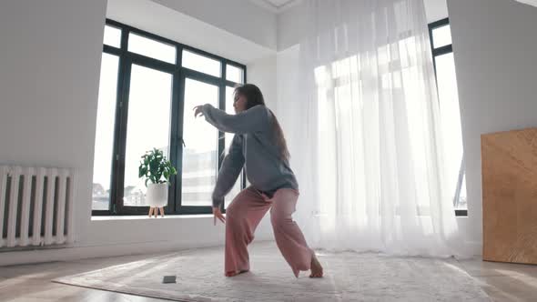 Modern Dancing  a Young Woman Dancing By the Music Coming From Her Phone alt