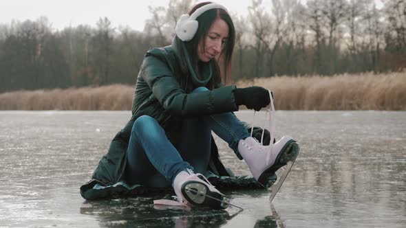 Young Woman Ice Skating on a Frozen Lake on a Freezing Winter Day. Legs of Skater on Winter Ice Rink alt