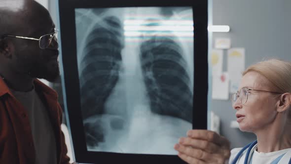 Doctor Showing X-ray to Black Man alt