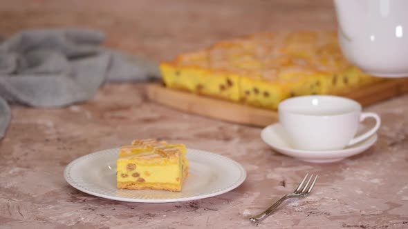 Polish cheesecake layered with lattice pattern with cup of tea Pouring tea into cup