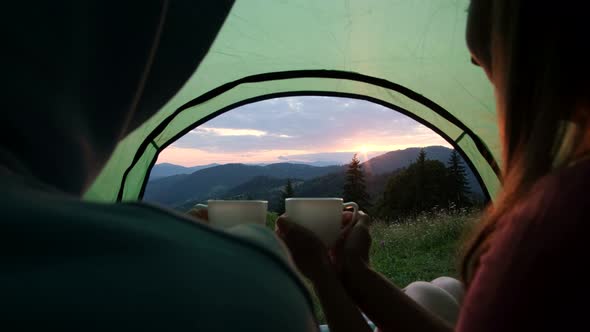 The feet of travelers rest, the couple lies and admires the mountains after climbing alt