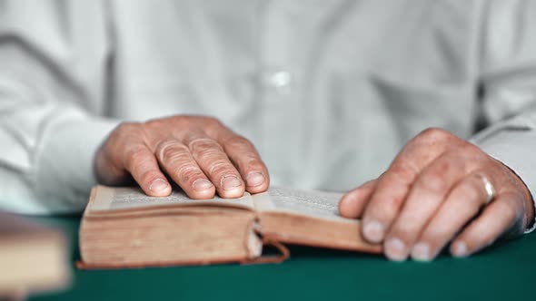 Elderly Grandfather Wrinkled Hands Reading Book at Library on Desk Closeup alt