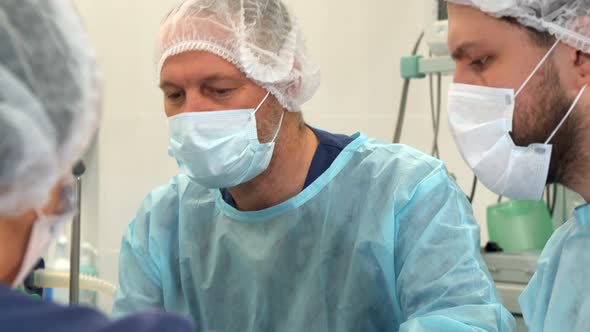 Nurse Wipes the Surgeon's Forehead at the Surgery