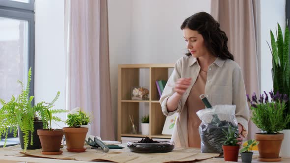 Happy Woman Planting Pot Flowers at Home alt