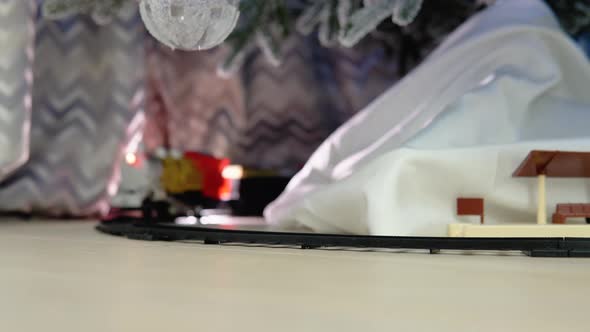 Christmas Train Traveling Under a Christmas Tree with Gift Bag and Presents alt