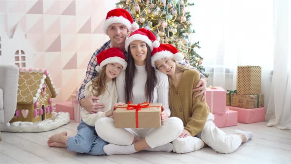 Happy Young Family with Kids Holding Christmas Presents