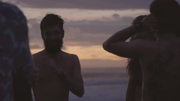 Friends Chatting on Beach at Dusk alt